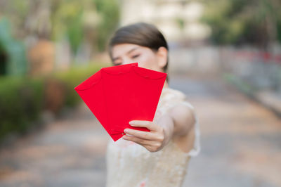 Midsection of woman holding red umbrella