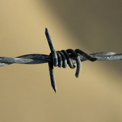 Close-up of barbed wire fence against clear sky