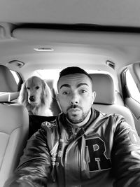 Portrait of mid adult man traveling with dog in car