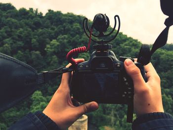 Cropped hands holding camera