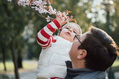 Full length portrait of mother and son on tree