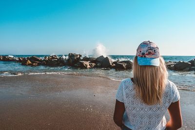 Portrait of woman on beach against clear sky