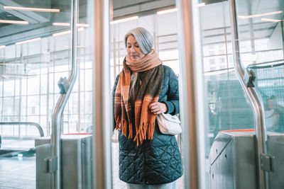 Mature woman standing at railroad station