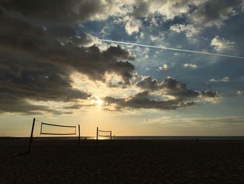 Beach volleyball net against sky during sunset