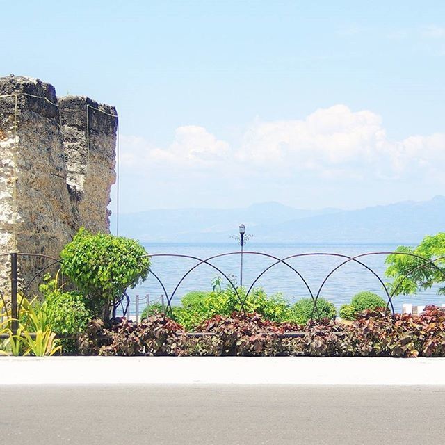 sea, water, sky, plant, horizon over water, built structure, architecture, nature, tranquil scene, beauty in nature, building exterior, tranquility, mountain, railing, growth, scenics, day, tree, no people, blue