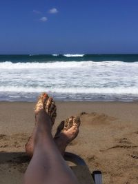 Low section of women sitting on beach