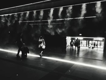 People walking on soccer field against sky