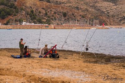 People sitting on beach by sea