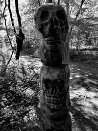 Statue amidst trees on field in forest