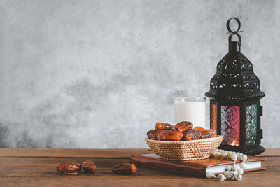 Fruits in basket on table against wall