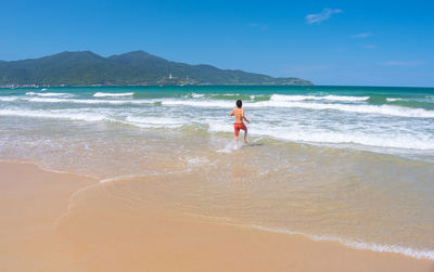 Full length of woman on beach against sky