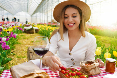 Woman eating strawberry in greenhouse