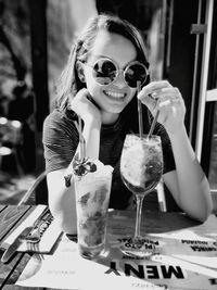 Portrait of a smiling young woman holding drink