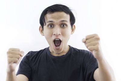 Portrait of man screaming against white background