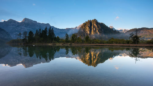 Scenic view of lake by mountains against sky