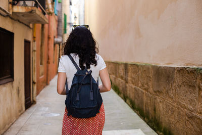 Rear view of woman standing on wall