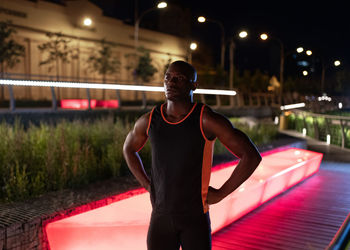 Exhausted ethnic runner on night street