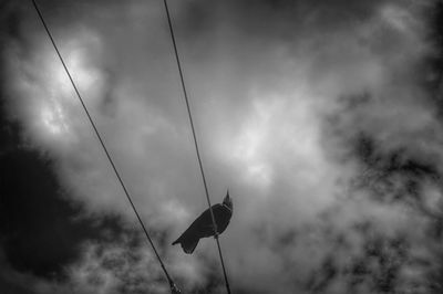 Low angle view of power lines against cloudy sky