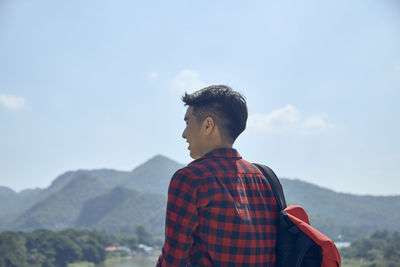 Man looking at mountain against sky