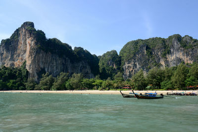 Sea in front of rock formation at island against sky