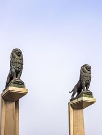 Low angle view of birds perching on statue