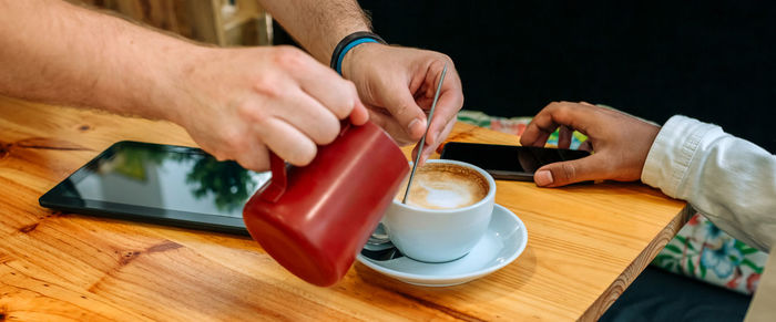 Midsection of man using mobile phone on table