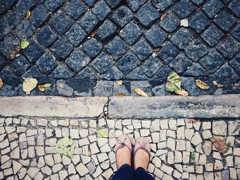 Low section of woman standing on sidewalk