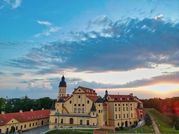 Buildings in town against cloudy sky