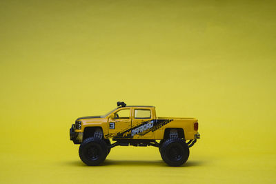 Toy car against yellow background