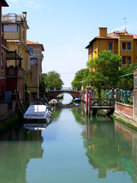 Canal amidst buildings against sky