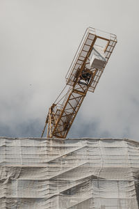 Low angle view of crane against sky