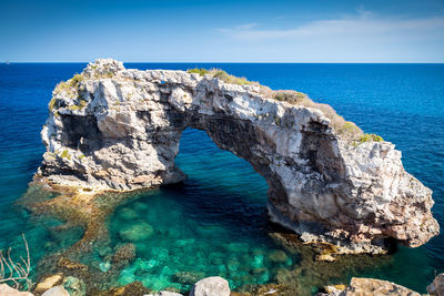 Rock formations in sea against sky