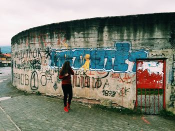 Man standing against graffiti wall