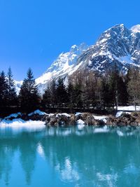 Scenic view of snowcapped mountains and lake against blue sky