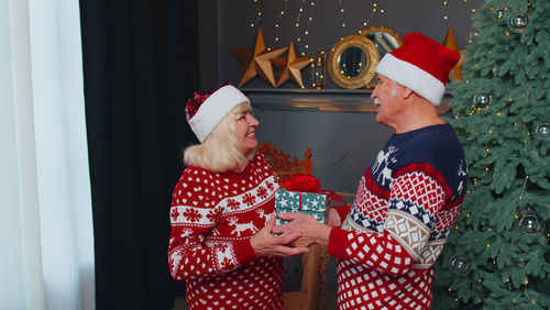 Senior couple wearing santa hat at home