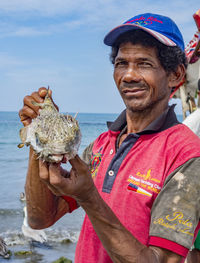 Portrait of smiling man holding sea