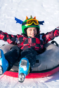 Boy sledding down the hill in snow tube