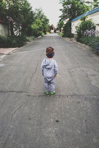 Rear view of boy walking on street