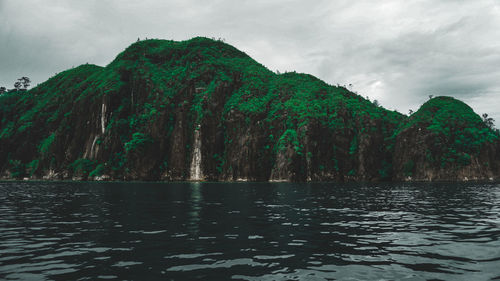 Scenic view of lake by mountain against sky