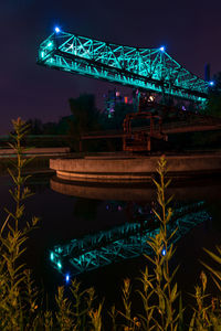 Low angle view of illuminated bridge against sky at night