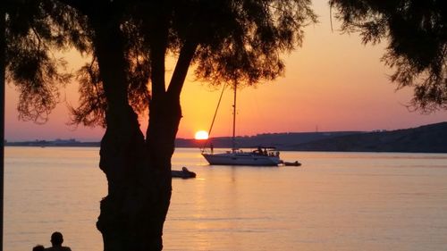 Silhouette sailboats moored on sea against sky during sunset
