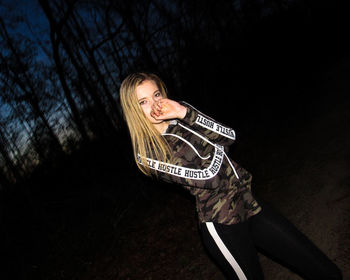 Young woman smiling against trees