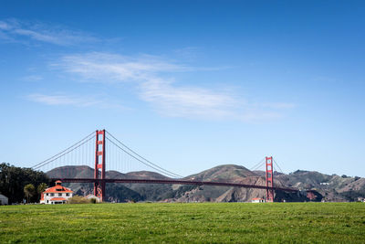 Suspension bridge over landscape against sky