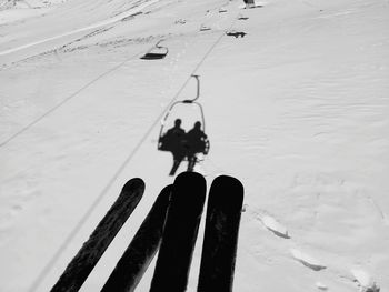 Low section of person walking on snow covered field