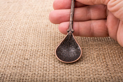 Cropped hand holding antique spoon at table