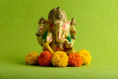 Statue of buddha against green background