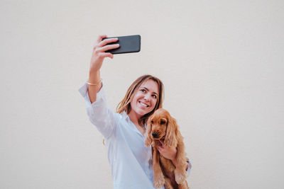 Portrait of woman photographing with dog