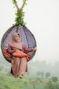 Portrait of woman with umbrella against sky