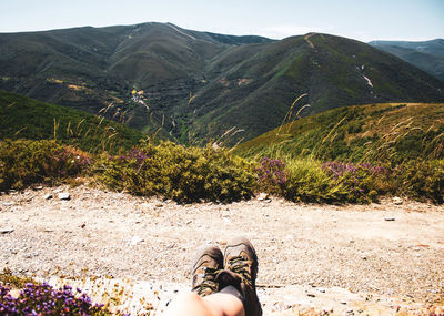 Legs in boots hanging in a forest mountains landscape