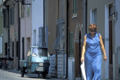 Man standing on street against buildings in city